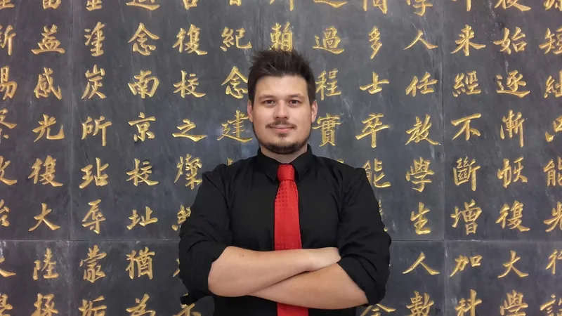 Konrad in front of a wall of Chinese characters at the NCCU library, Taipei